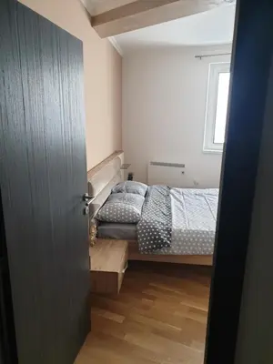 a small bedroom with a bed and a window at Apartman Noalux 2 Kopaonik in Kopaonik