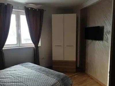 a bedroom with a bed and a cabinet and a television at Apartman Noalux 2 Kopaonik in Kopaonik