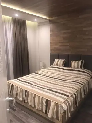 a bedroom with a large bed with a wooden wall at Apartman Premier 32 Milmari in Kopaonik