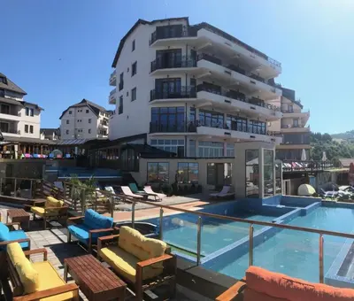 a hotel with a swimming pool and a building at Apartman Premier 32 Milmari in Kopaonik