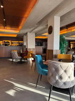a lobby with colorful chairs and tables in a restaurant at Apartman Premier 32 Milmari in Kopaonik