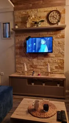 a living room with a tv on a brick wall at Apartman Premier 32 Milmari in Kopaonik