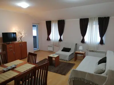 a living room with a couch and a table at Apartman Horizont Kop in Kopaonik