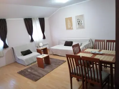a living room with a bed and a dining room table at Apartman Horizont Kop in Kopaonik