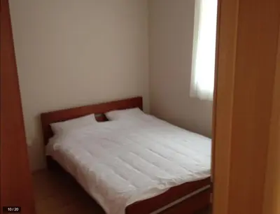 a bedroom with a bed with white sheets and a window at Apartman Horizont Kop in Kopaonik