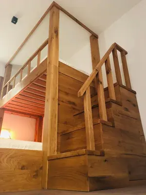 a wooden bunk bed with wooden stairs in a room at Sunside Oak - 206 in Kopaonik