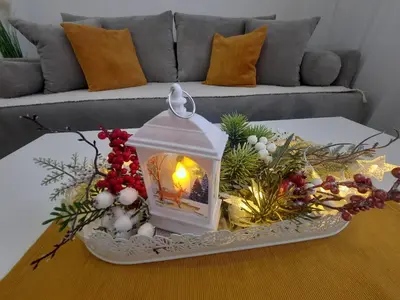 a table with a lantern and christmas decorations on it at Bankovic Apartman in Vrnjačka Banja
