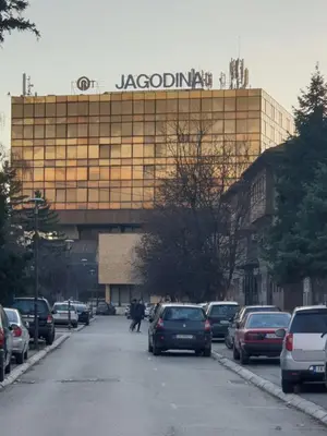 a large building with a sign on top of it at Apartman Park Jagodina-studio u centru grada FREE parking in Jagodina