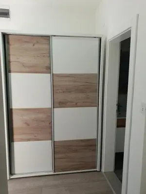 a sliding glass door in a room with a mirror at IN Apartmani in Kruševac