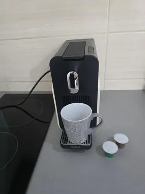 a coffee maker with a cup on a counter at IN Apartmani in Kruševac