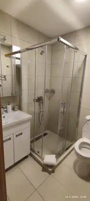 a bathroom with a shower with a toilet and a sink at Apartman Studio Lux u Kraljevim Čardacima in Kopaonik