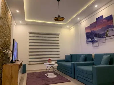 a living room with blue couches and a tv at Milmari Resort N73 Ski & Spa in Kopaonik
