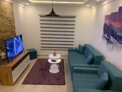 a living room with a blue couch and a tv at Milmari Resort N73 Ski & Spa in Kopaonik