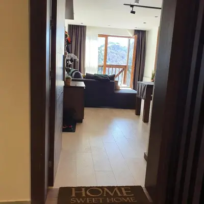 a hallway with a living room with a couch and a window at MK Apartments Zoned 2 Spa&Wellness in Cajetina