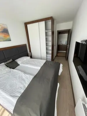 a bedroom with two beds and a flat screen tv at MK Apartments Zoned 2 Spa&Wellness in Cajetina