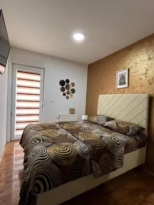 a bedroom with a large bed in a room at Apartman Lux in Vranje