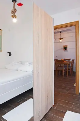 a room with a bed and a dining room with a table at Apartman Paunovi Čardaci sa garažnim mestom in Kopaonik