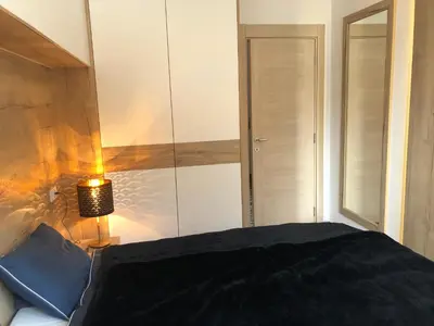 a bedroom with a bed and a lamp and a mirror at Vila Montana Kopaonik Apartman 6 in Kopaonik