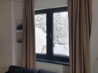 a window with a view of a snow covered yard at Vila Montana Kopaonik Apartman 6 in Kopaonik