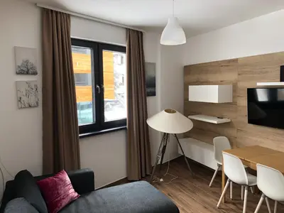 a living room with a couch and a table at Vila Montana Kopaonik Apartman 6 in Kopaonik