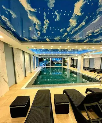 a large swimming pool with a ceiling filled with clouds at President Kop A 407 in Kopaonik