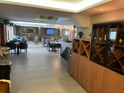 a restaurant with tables and chairs and a bar at President Kop A 407 in Kopaonik