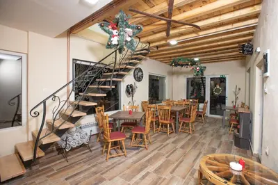 a dining room with a staircase and tables and chairs at Apartmani SP Jovanovic in Crni Vrh