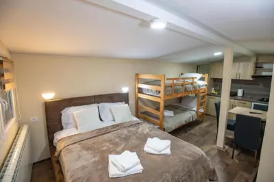 a bedroom with a bed with two bunk beds at Apartmani SP Jovanovic in Crni Vrh