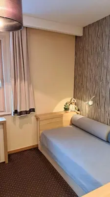 a small bedroom with a bed and a window at GALA Kop Apartman in Kopaonik