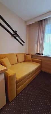 a couch in a room with a window at GALA Kop Apartman in Kopaonik