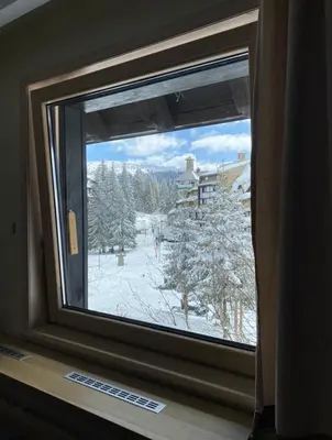 a window with a view of a snow covered yard at GALA Kop Apartman in Kopaonik