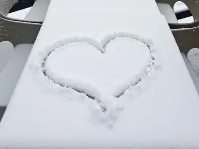 a heart drawn in the snow on a car at GALA Kop Apartman in Kopaonik