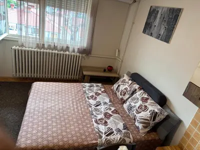 a bedroom with a bed with pillows and a window at Sofi Apartment Nis in Niš
