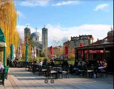 a group of people sitting at tables and chairs at Sofi Apartment Nis in Niš