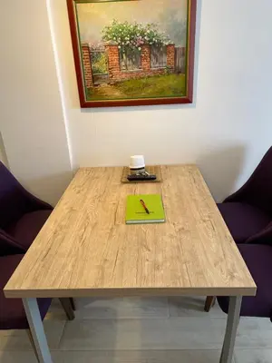 a wooden table with a green notebook on top of it at Studio apartman p13 in Kopaonik