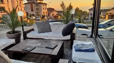 a patio with couches and a table on a balcony at Studio apartman p13 in Kopaonik