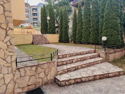 a set of stone stairs in a park with trees at Apartman In Lux in Vrnjačka Banja