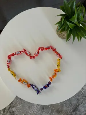 a heart beaded necklace on a white plate at Apartman In Lux in Vrnjačka Banja