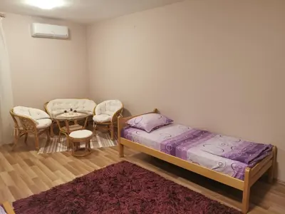 a bedroom with a bed and a table and chairs at Jumiko Apartments in Vrnjačka Banja
