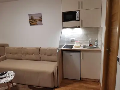 a living room with a couch and a kitchen at JORDAN Apartment KC 9C 35 Kopaonik in Kopaonik