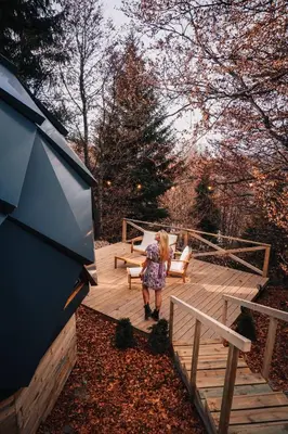 a woman is standing on a wooden deck at Armadillo Houses in Kopaonik