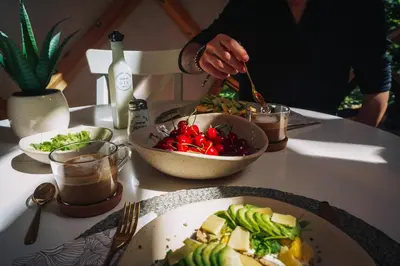 a table with plates of food and a bowl of vegetables at Armadillo Houses in Kopaonik