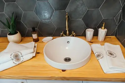 a bathroom counter with a sink and towels at Armadillo Houses in Kopaonik