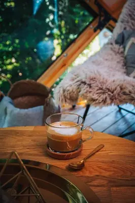 a cup of coffee sitting on a wooden table at Armadillo Houses in Kopaonik