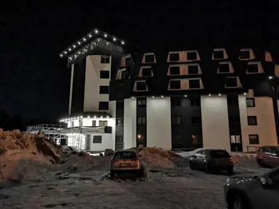 a building with cars parked in front of it at night at Suncana planina apartman 103 in Kopaonik