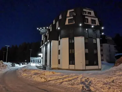 a large building in the snow at night at Suncana planina apartman 103 in Kopaonik