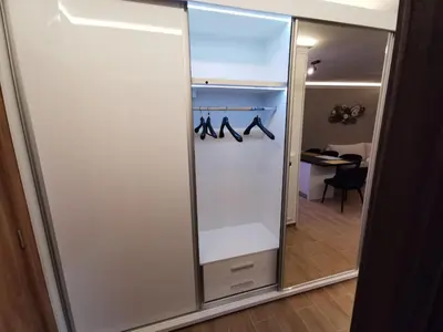a sliding glass door with hangers and shoes at Suncana planina apartman 103 in Kopaonik