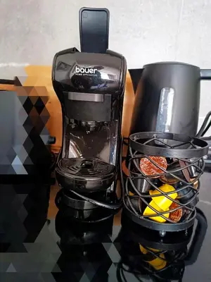 a black coffee maker and a cup on a counter at President KOP A515 in Kopaonik