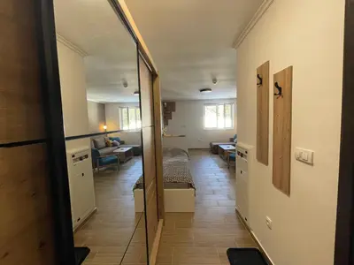 a hallway with a mirror and a room with a bed at Vili.Kop studio in Kopaonik