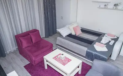 a living room with a couch and a chair at Family Apartmani Le in Leskovac